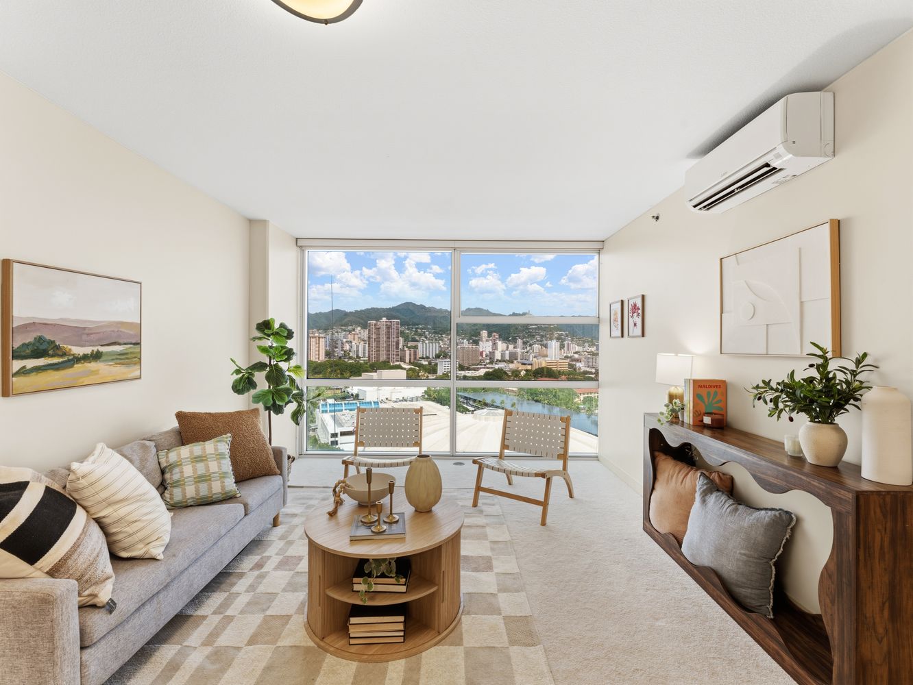 Living room with sofa and floor-to-ceiling windows overlooking the city and mountains